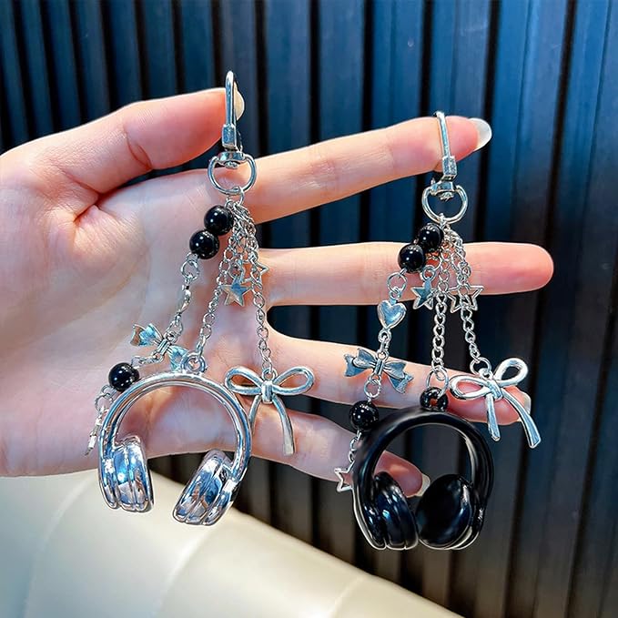 Headphone charm keychains in blue and black held in hand